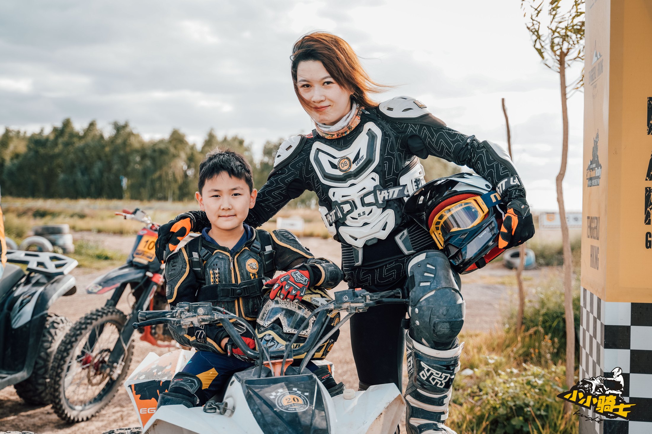 Parent and child in protective gear after a rally training session.