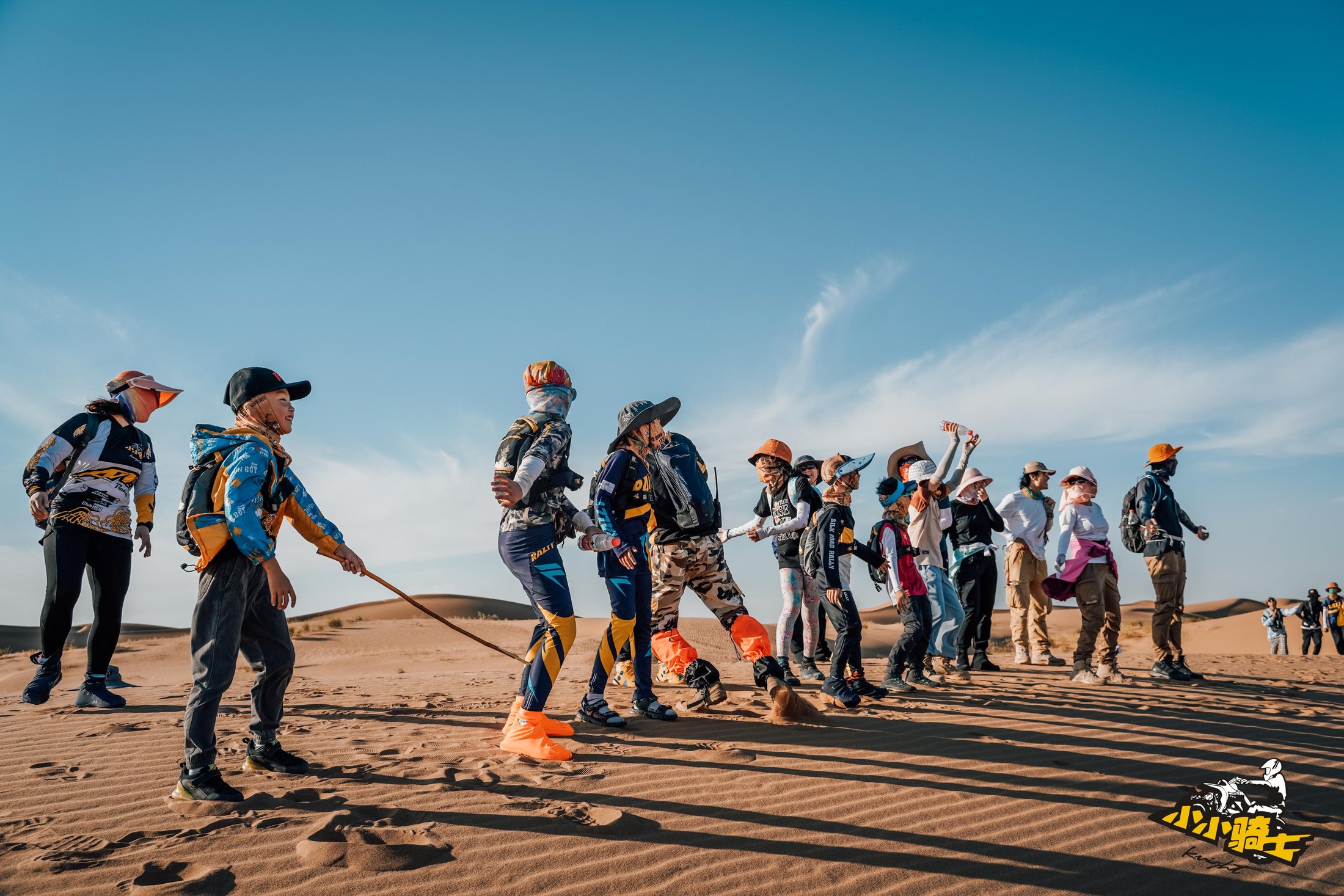 Camp participants working together on desert dunes.